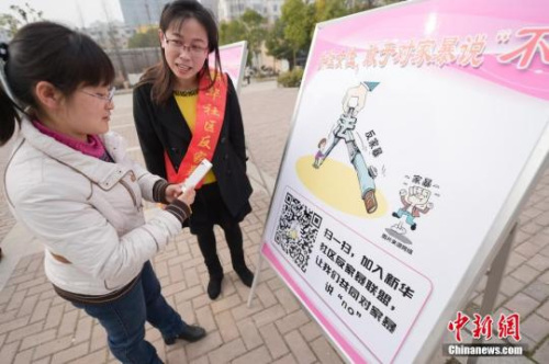 資料圖：今年3月8日，安徽合肥新華社區(qū)志愿者夏一瓊(右)向市民普及反家暴相關(guān)法律知識(shí)。鐘欣 攝
