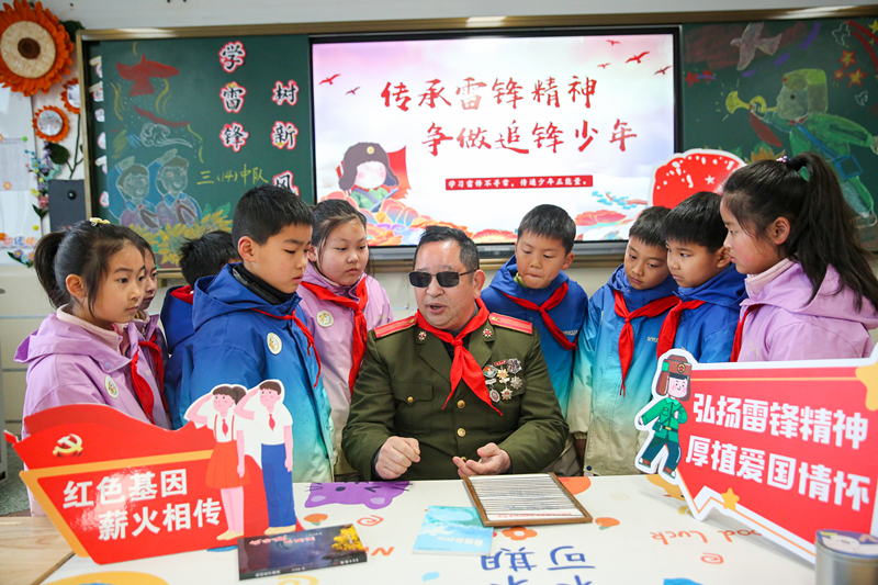 2025年3月3日，江蘇南通如皋市安定小學里，傷殘軍人許波銀在思政小課堂上向?qū)W生講述雷鋒故事。